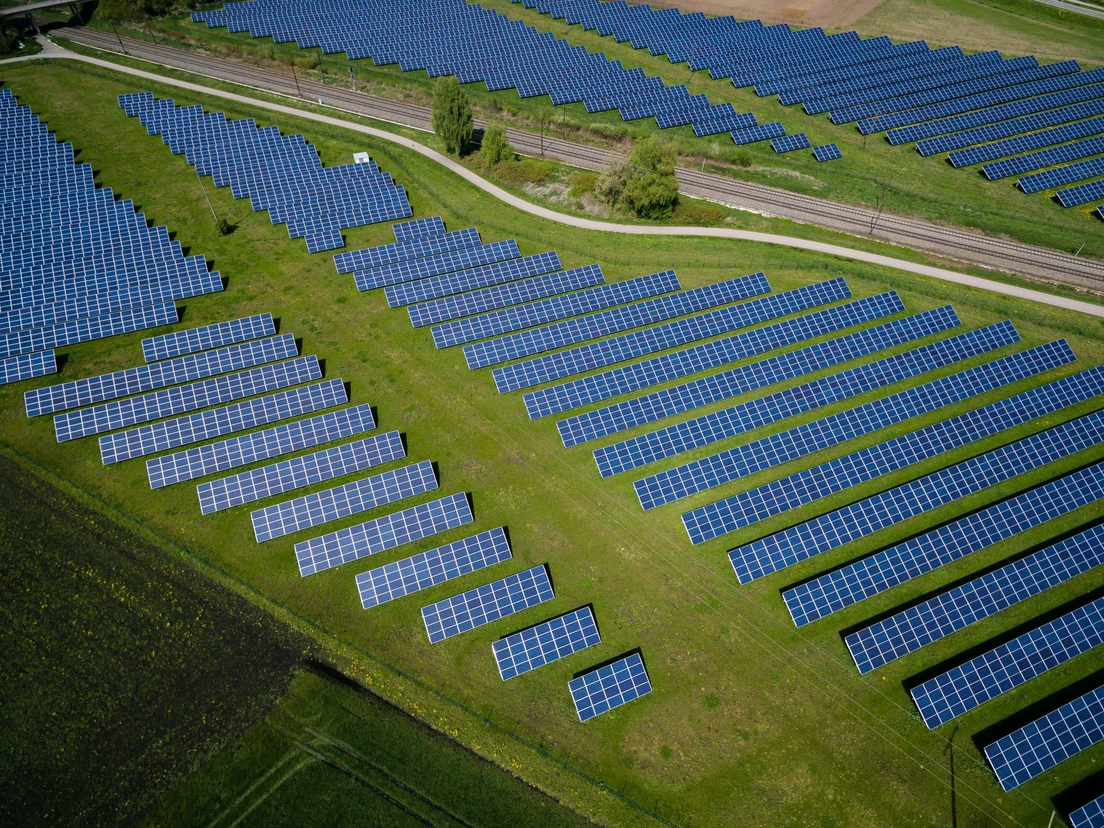 Aerial view of a solar farm laid out across green fields