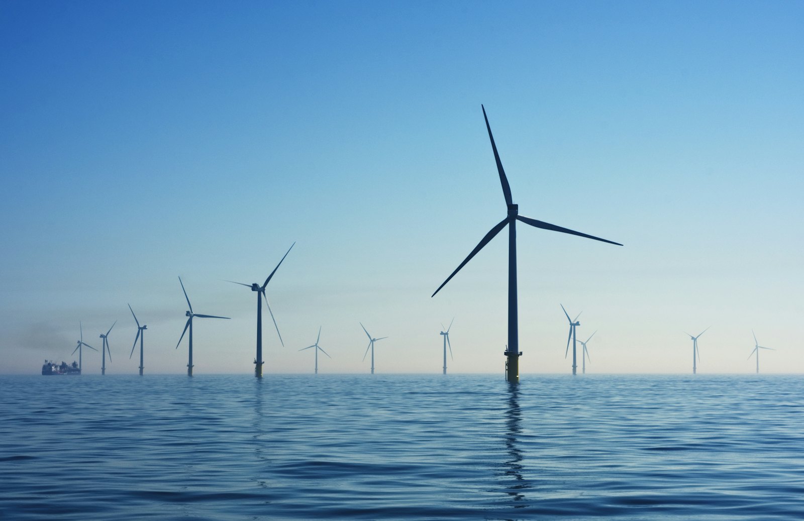 Offshore wind turbines standing in calm blue sea