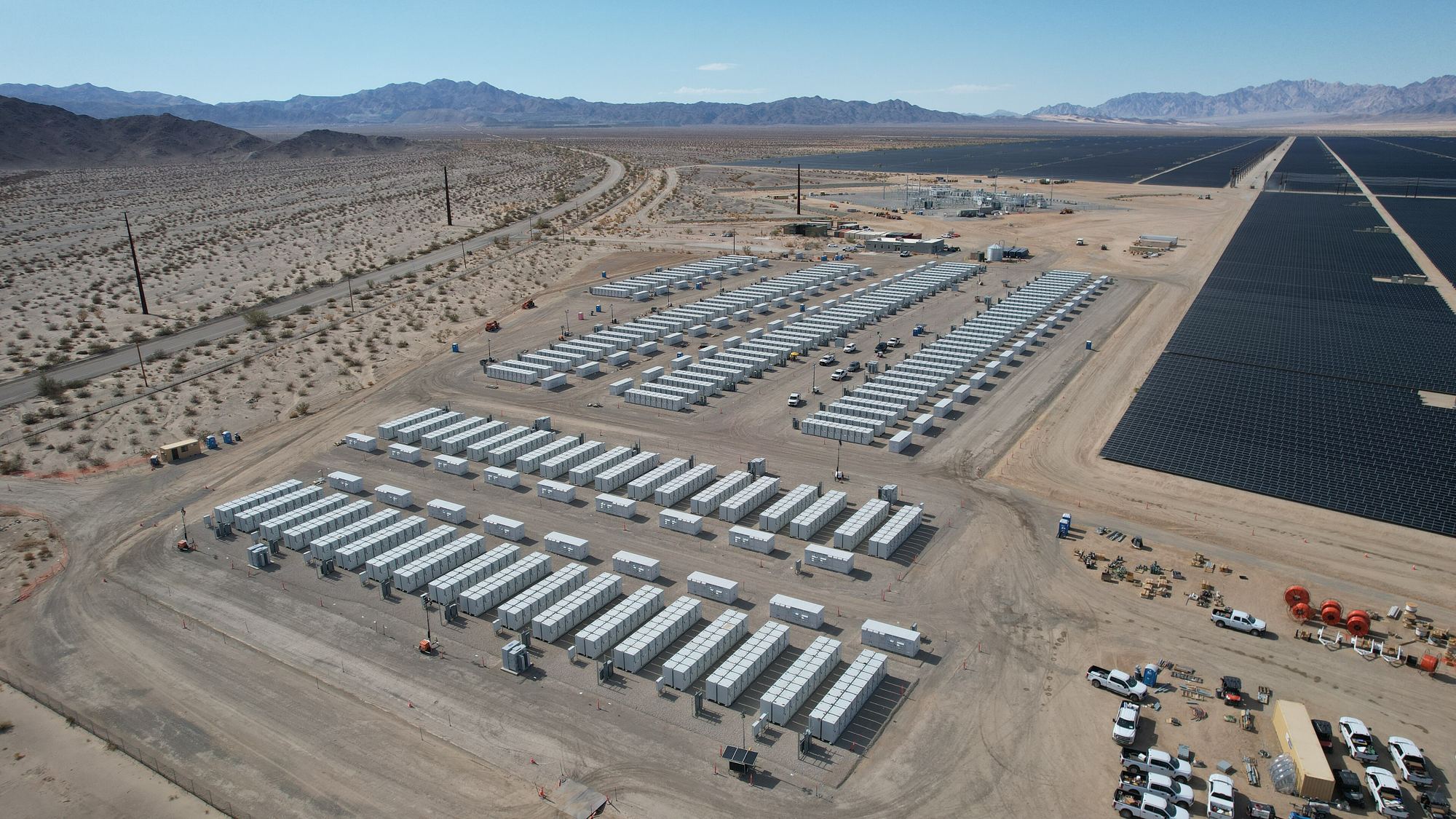 Aerial view of a battery energy storage system beside a desert solar farm